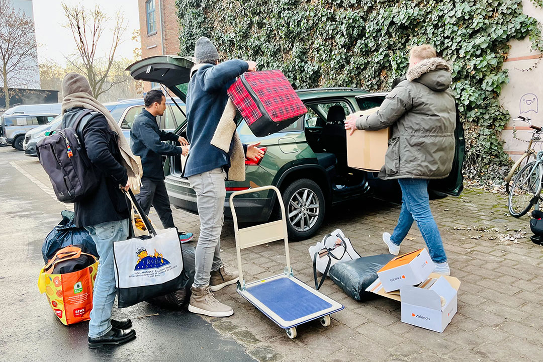Nachbar:innen beladen ein Auto mit Spenden für Obdachlose
